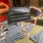 A hand holds up a home-made protective mask